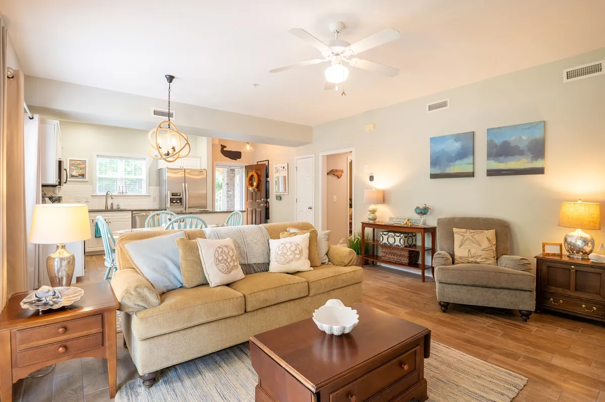 A comfortable and inviting living room scene with a sofa adorned with decorative pillows, a coffee table with a centerpiece, and tasteful artwork on the wall. The space feels perfect for gatherings or relaxed evenings in.